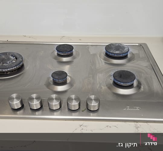 כיריים גז עם ארבעה מבערים וכפתורי שליטה